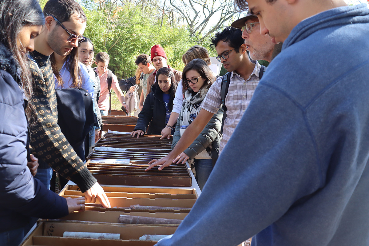 Students inspect core samples at a geothermal dig site on Duke University's campus.